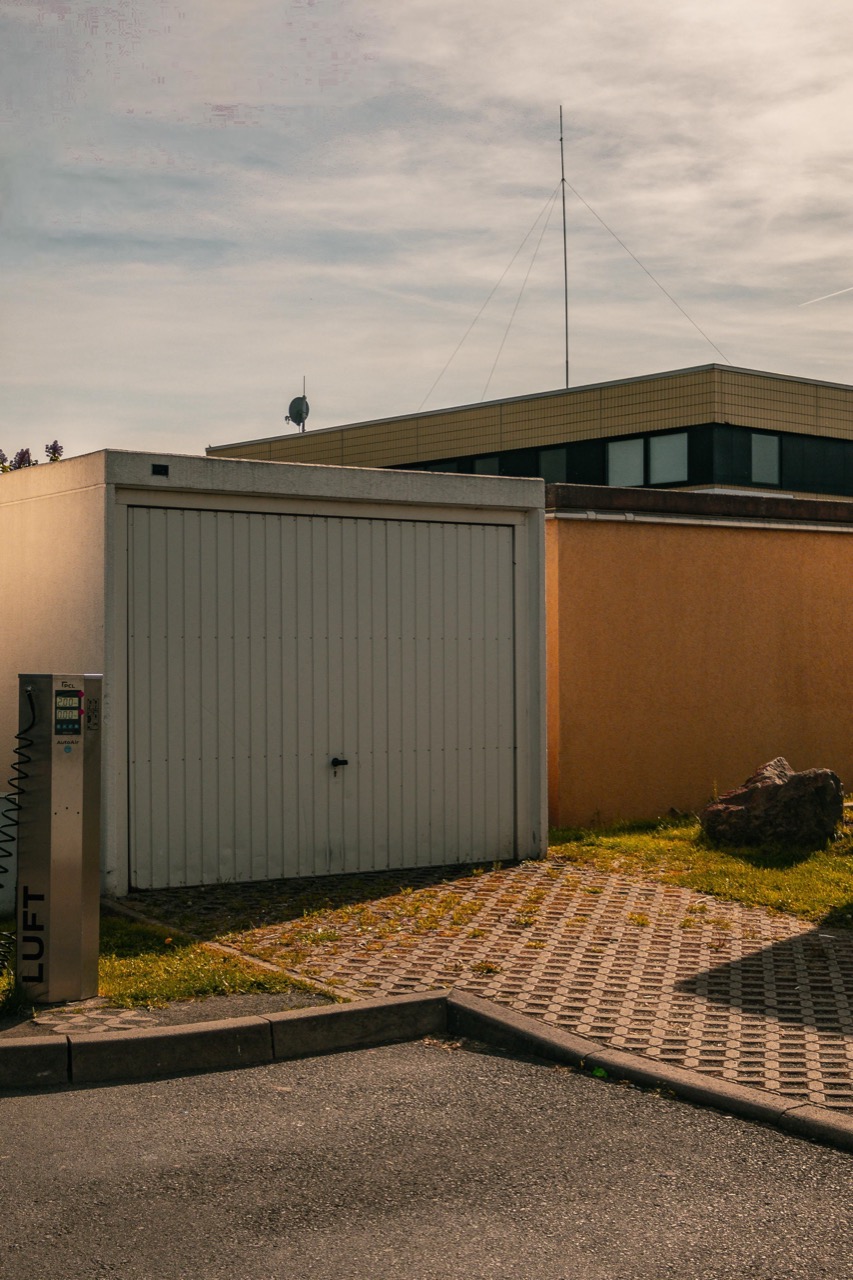 Freistehende Einzelgarage mit weißem Tor – Garagenparken kann den Kfz-Versicherungsbeitrag senken
